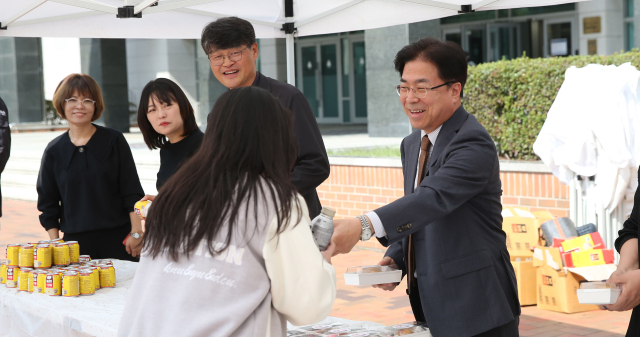 성한기 대구가톨릭대 총장(오른쪽)이 학생들에게 간식을 전달하고 있다. 대구가톨릭대 제공