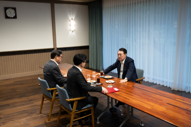 윤석열 대통령이 21일 서울 용산 대통령실 앞 파인그라스에서 국민의힘 한동훈 대표를 만나 대화하고 있다. 이 자리에는 정진석 대통령 비서실장이 배석했다. 연합뉴스