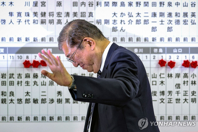 이시바 시게루 일본 총리가 27일 중의원 선거(총선) 결과가 표시된 자민당 본부에서 퇴장하며 손을 들어 보이고 있다. 연합뉴스