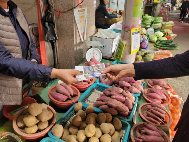 29일 오후 대구 북구 칠성시장의 한 점포에서 시민이 상인에게 온누리상품권을 건네고 있다. 박성현 기자