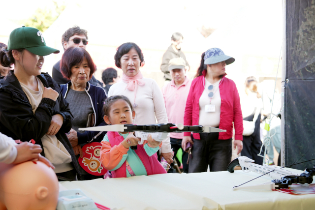 청송사과축제를 방문한 한 소녀가 목표물을 향해 활 시위를 겨냥하고 있다. 청송군 제공