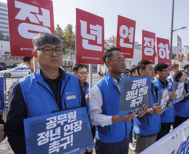 30일 오전 서울 용산구 대통령실 앞에서 대한민국공무원노동조합총연맹이 개최한 기자회견에서 참석자들이 공무원 노후 소득 해소와 정년 연장을 촉구하는 팻말을 들고 있다. 연합뉴스