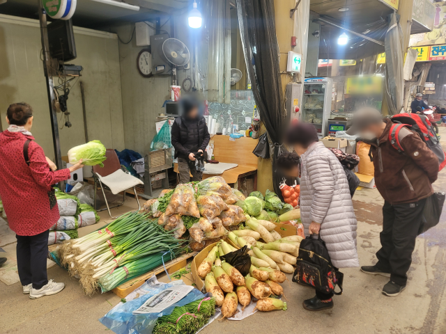 7일 오전 찾은 대구 북구 팔달신시장의 한 점포. 시민들이 배추와 무의 가격을 물어보고 있다. 박성현 기자