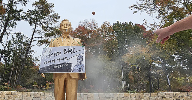 10일 오후 경북 경산시 영남대학교에서 영남대 민주동문회원들이 대학 내 설치된 박정희 동상에 계란을 던지고 있다. 연합뉴스