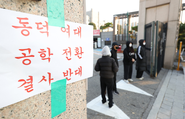 동덕여자대학교의 남녀공학 전환 추진 논의에 반발한 학생들이 12일 오전 서울 성북구 동덕여대 본관에서 항의하며 교문을 막고 서 있다. 학교 측은 남녀공학 전환에 대해 확정된 사안이 아니라는 입장을 밝혔다. 연합뉴스