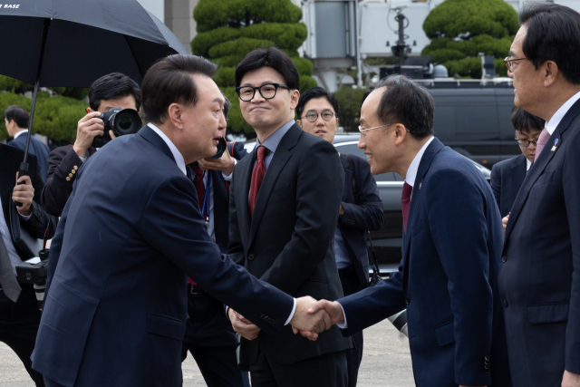 윤석열 대통령이 14일 성남 서울공항에서 31차 아시아태평양경제협력체(APEC) 및 19차 주요 20개국(G20) 정상회의 참석을 위해 출국하며 환송 나온 국민의힘 추경호 원내대표와 악수하고 있다. 가운데는 한동훈 대표. 연합뉴스