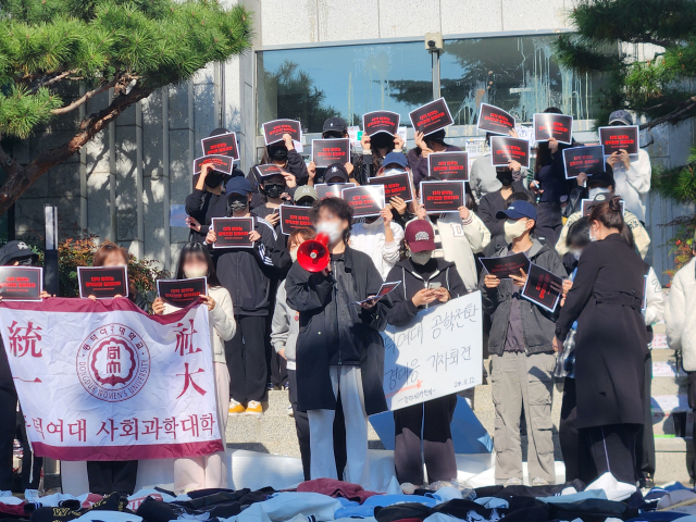 동덕여자대학교의 남녀공학 전환 추진 논의에 반발한 학생들이 지난 12일 오전 서울 성북구 동덕여대 본관 앞에서 열린 기자회견에서 손팻말을 들고 있다. 연합뉴스