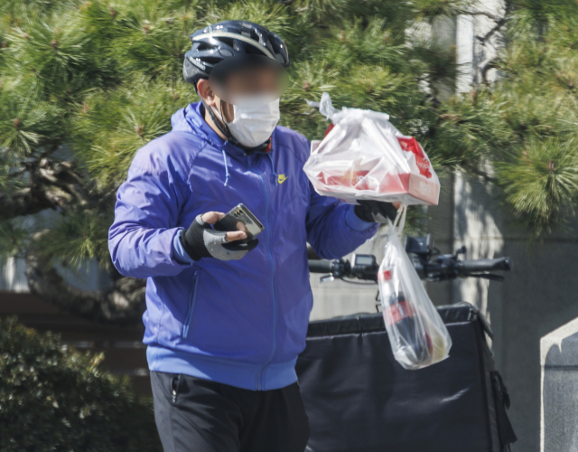 31일 오후 서울 서초구의 한 건물 앞에서 배달 노동자가 음식 배달을 하고 있다. 배달의민족·쿠팡이츠·요기요·땡겨요 등 배달 플랫폼 업체와 소상공인연합회·한국외식산업협회 등 입점 업체 대표들은 지난 30일 수수료 부담 완화 방안 등을 놓고 9번째 논의를 이어갔지만, 또 합의에 이르지 못했다. 하지만 이날 회의에서 참석 주체들은 라이더 위치정보 공유 및 부담 항목 영수증 표기 등 다른 쟁점에서는 공감대를 찾았다. 업계 주체들은 다음 달 추가 회의를 열어 수수료 합의안의 도출을 다시 시도할 예정이다. 연합뉴스