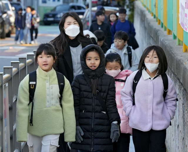 대구 아침 최저 기온이 2.8℃까지 내려가며 초겨울 추위가 찾아온 18일 대구 시내 한 초등학교에서 학생들이 두꺼운 외투 차림으로 등교를 하고 있다. 김영진 기자 kyjmaeil@imaeil.com