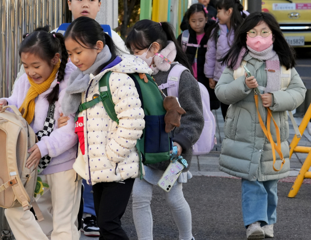 대구 아침 최저 기온이 2.8℃까지 내려가며 초겨울 추위가 찾아온 18일 대구 시내 한 초등학교에서 학생들이 두꺼운 외투 차림으로 등교를 하고 있다. 김영진 기자 kyjmaeil@imaeil.com