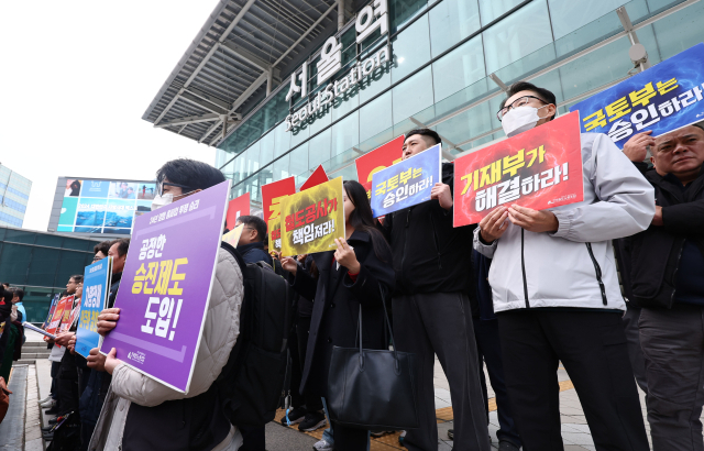 21일 서울역 앞에서 열린 전국철도노동조합 12월 총파업 돌입 예고 기자회견에서 참가자들이 손팻말을 들고 있다. 연합뉴스