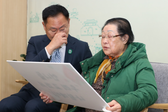 김재욱 칠곡군수와 이원순 할머니가 할머니들의 시와 그림이 국어교과서에 실린 것을 자축하며 기념촬영을 하고 있다. 칠곡군 제공