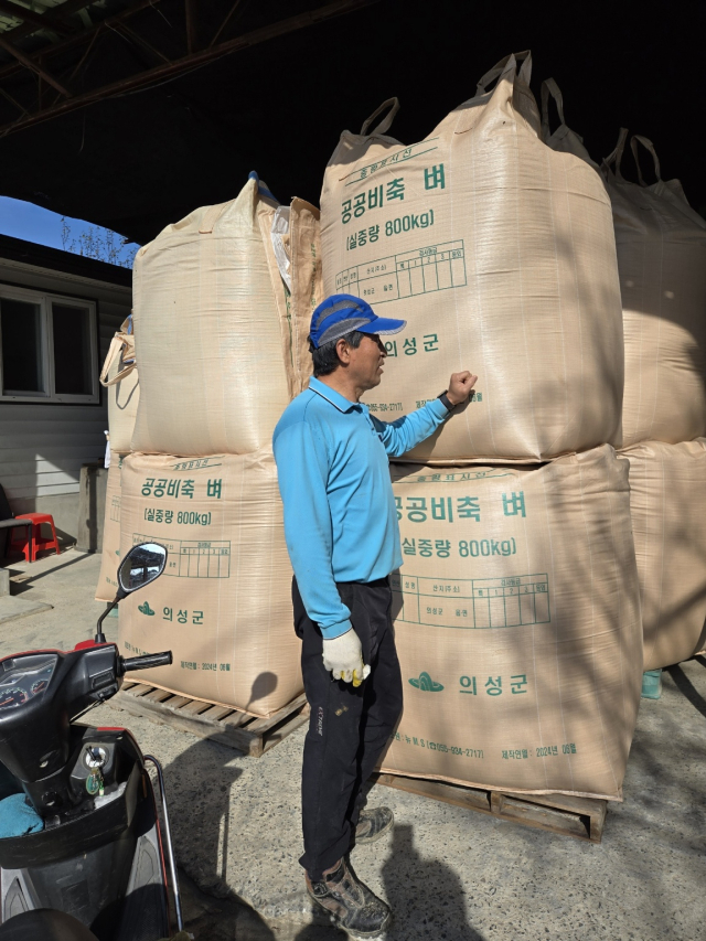 경북 의성군 한 농가에 쌓여 있는 800kg 벼 포대를 농민이 살펴보고 있다. 의성군 제공