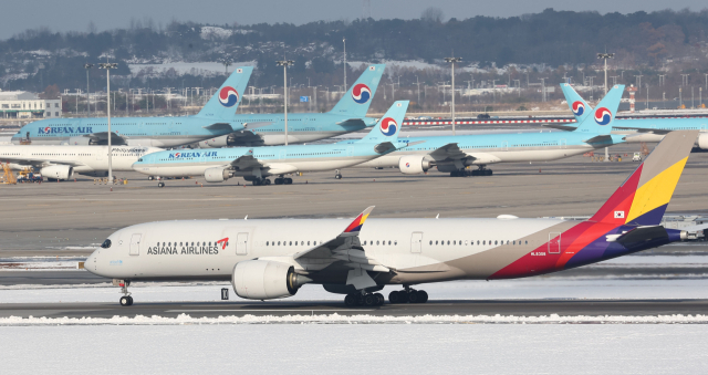 28일 인천 영종도 인천국제공항 활주로와 주기장에 대한항공-아시아나항공 여객기가 보이고 있다. 유럽연합 집행위원회는 28일(현지시간) 대한항공과 아시아나항공의 결합을 최종 승인했다. 연합뉴스