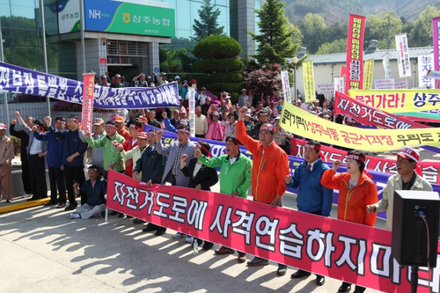 지난 2012년 상주시민 1천여명이 중동농협 앞에서 낙동 공군사격장 폐쇄 궐기대회를 하고 있다. 오른쪽 4번째 빨간 점프 복장이 강영석 현 시장으로 당시에는 경북도의원 신분으로 궐기대회를 주도했다. 상주시 제공