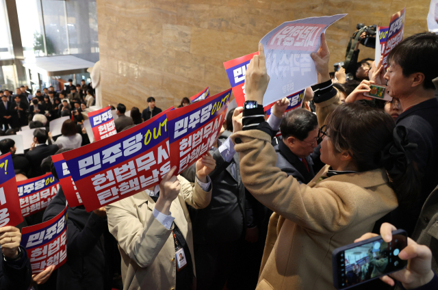 국민의힘 추경호 원내대표를 비롯한 의원 및 당 관계자들이 5일 오전 국회 로텐더홀 계단에서 더불어민주당의 감사원장과 검사들에 대한 탄핵 추진 규탄대회를 하던 중 본회의에 참석하던 민주당 몇몇 의원들이 항의하며 고성이 오가고 있다. 연합뉴스