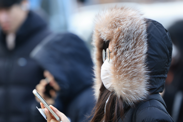 전국 대부분의 아침 기온이 영하로 떨어진 지난달 29일 오전 서울 세종대로사거리에서 두꺼운 옷을 입은 시민이 횡단보도를 건너고 있다. 연합뉴스