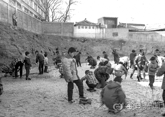 1971년 12월 30일 대구 내당국민(초등)학교에 조성된 미니 안전스케이트장에 어린이들이 몰려 나와 썰매를 타고 있다. 얼음을 지치다 안전사고가 잦자 당국은 삼덕·동부·내당·옥산·인지국교(초교) 등 5곳 운동장에 안전스케이트장을 만들었다. 사진=매일아카이빙센터