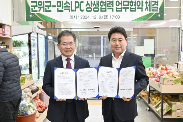 김진열(왼쪽) 대구 군위군수와 권혁수(오른쪽) 민속LPC 대표가 농·축산물 유통, 소비 확대를 위한 업무협약을 체결하고, 기념 사진을 촬영하고 있다. 군위군 제공