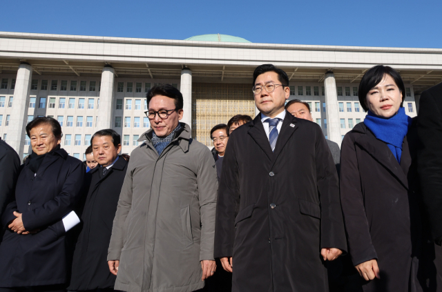 더불어민주당 의원들이 14일 오전 국회 앞에서 탄핵 촉구 집회에 참석한 시민들에게 인사하기 위해 이동하고 있다. 연합뉴스