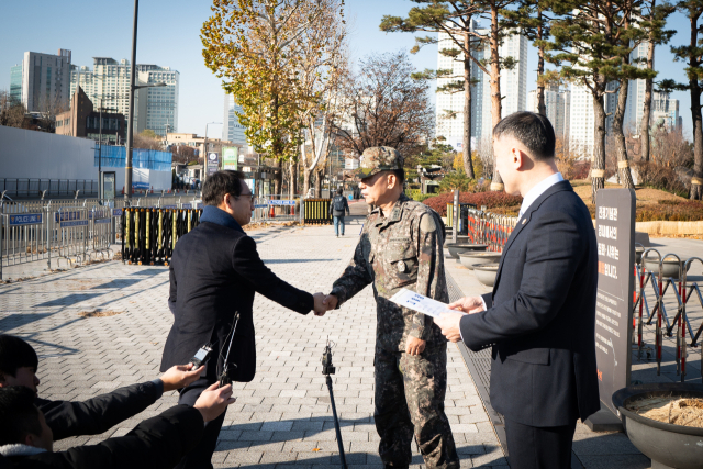 더불어민주당 박선원 의원과 박헌수 국방부 조사본부장이 9일 서울 용산구 국방부 민원실 앞에서 열린 박안수 육군참모총장, 여인형 방첩사령관 등에 대한 내란 혐의 고발 기자회견에서 악수를 하고 있다. 연합뉴스