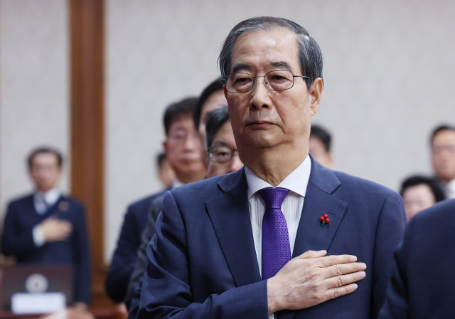 한덕수 대통령 권한대행 국무총리가 17일 서울 종로구 정부서울청사에서 열린 국무회의에서 국기에 경례하고 있다. 연합뉴스