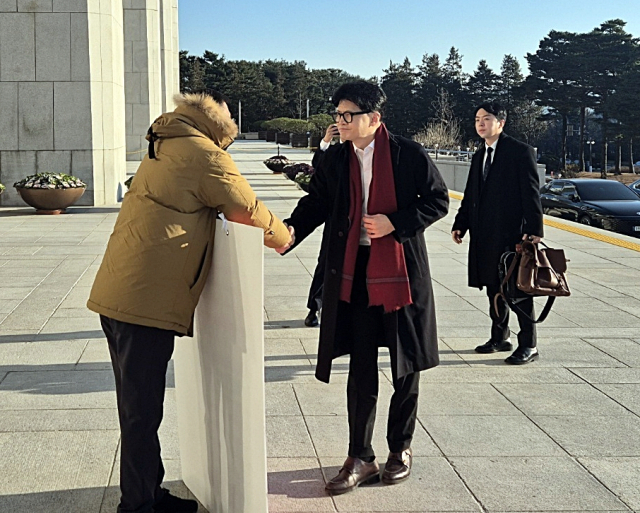 14일 오전 국민의힘 한동훈 대표가 국회 본청 앞에서 탄핵 찬성을 촉구하며 1인 시위를 하던 국민의힘 김상욱 의원에게 다가가 악수를 청하고 있다. 연합뉴스