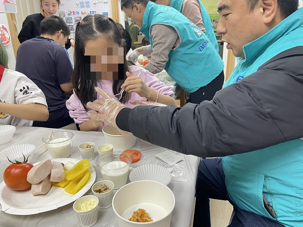 부산항만공사 직원들이 지난 23일 부산 중구 희망지역아동센터에서 지역농산물을 활용해 저소득층 어린이 도시락 만들기 봉사활동을 하고 있다. [사진=BPA]