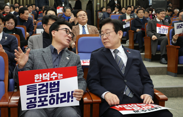 더불어민주당 이재명 대표(앞줄 오른쪽)와 김민석 최고위원이 24일 국회에서 열린 의원총회에서 대화하고 있다. 연합뉴스