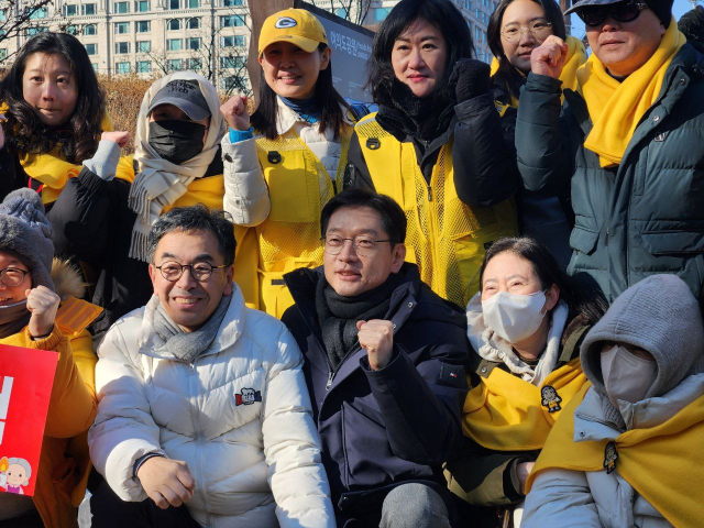 김경수 전 경남지사가 14일 서울 여의도 국회 앞에서 열린 촛불집회에 참석해 노무현시민센터 자원봉사자들과 윤석열 대통령 탄핵을 촉구하고 있다. 연합뉴스