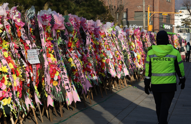 윤석열 대통령 탄핵심판 첫 변론준비기일을 하루 앞둔 26일 서울 종로구 헌법재판소 앞에 윤 대통령 지지자들의 화환이 놓여 있다. 연합뉴스