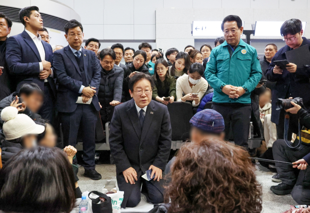 더불어민주당 이재명 대표가 29일 오후 전남 무안국제공항에서 무릎을 꿇은 채 제주항공 여객기 폭발사고 탑승객 가족들을 위로하고 있다. 연합뉴스