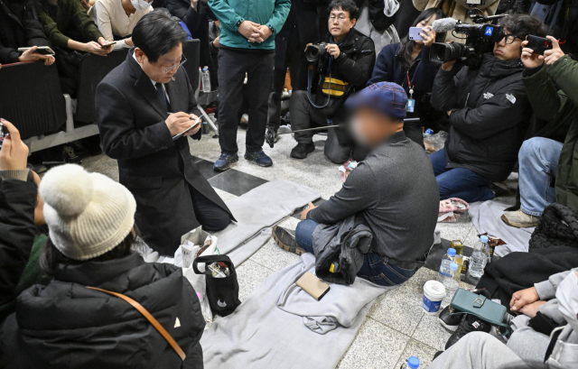 더불어민주당 이재명 대표가 29일 오후 전남 무안국제공항에서 제주항공 여객기 폭발사고 탑승객 가족들을 위로하며 요청사항을 메모하고 있다. 연합뉴스