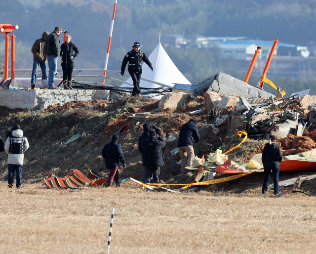 31일 오후 전남 무안군 무안국제공항 제주항공 여객기 참사 현장에서 미국 국가교통안전위원회(NTSB)와 보잉사 관계자, 국토부 항공철도사고조사위원회가 참사 원인으로 지목되고 있는 로컬라이저(방위각시설)가 있는 둔덕을 살펴보고 있다. 연합뉴스