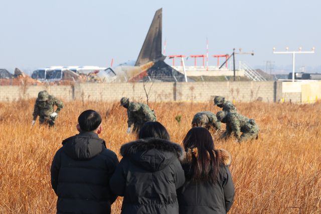 2일 오전 전남 무안군 무안국제공항 제주항공 여객기 참사 현장에서 시민들이 수색 현장을 바라보고 있다. 연합뉴스