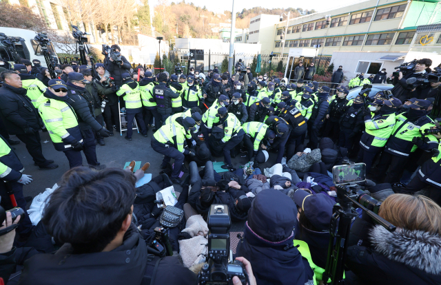 윤석열 대통령에 대한 체포영장 발부 사흘째인 2일 서울 용산구 한남동 대통령 관저 정문 앞 도로에 누워있는 지지자들을 경찰들이 해산시키려 하고 있다. 연합뉴스