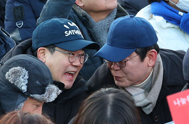 더불어민주당 이재명 대표가 지난 28일 서울 종로구 경복궁 인근에서 윤석열즉각퇴진·사회대개혁 비상행동 주최로 열린 촛불 집회에서 박찬대 원내대표와 대화하고 있다. 연합뉴스