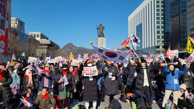 4일 오후 광화문 광장에서 열린 보수집회에서 참가자들이 피켓과 태극기, 성조기 등을 흔들고 있다. 남정운 기자