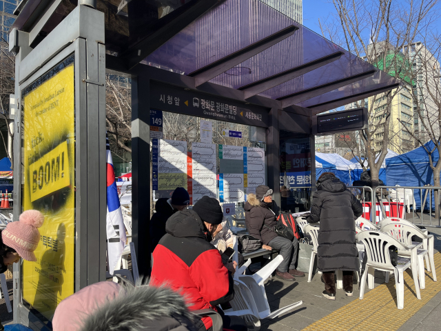 11일 오전 광화문 인근 버스 정류장이 집회 참가자들 쉼터로 바뀌었다. 정두나 기자