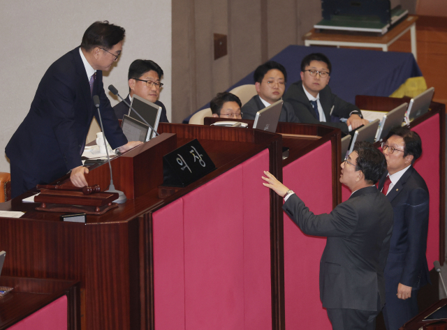 8일 오후 국회 본회의에서 대통령 권한대행 체제에서 재의요구권(거부권)이 행사돼 국회로 돌아온 내란 특검법, 김건희 여사 특검법, 양곡관리법 개정안 등 농업 관련 법안 4개, 국회법 개정안, 국회증언감정법 개정안 이 재표결 끝에 부결된 후 야당 의원들이 밖으로 나서자 국민의힘 권성동 원내대표가 우원식 국회의장에게 무언가 이야기하고 있다. 연합뉴스