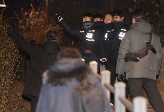 고위공직자범죄수사처(공수처)와 경찰이 윤석열 대통령에 대한 2차 체포영장 집행에 나선 15일 서울 용산구 한남동 대통령 관저 인근 매봉산 등산로 입구에서 형사기동대원들이 현장을 살피고 있다. 연합뉴스