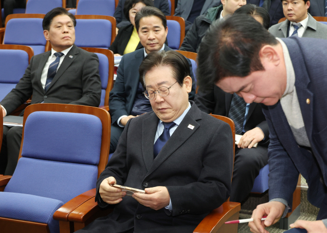 더불어민주당 이재명 대표가 15일 국회에서 열린 의원총회에 입장해 휴대전화를 살펴보고 있다. 연합뉴스