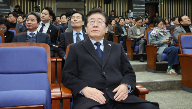 더불어민주당 이재명 대표가 15일 국회에서 열린 의원총회에 입장해 윤석열 대통령을 태운 차량이 고위공직자범죄수사처로 향하는 뉴스를 바라보고 있다. 연합뉴스