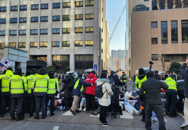 윤석열 대통령 구속영장 심사를 앞둔 18일 서울 마포구 서부지법 앞에서 경찰이 점거 농성 중인 윤 대통령 지지자들을 해산시키고 있다. 연합뉴스