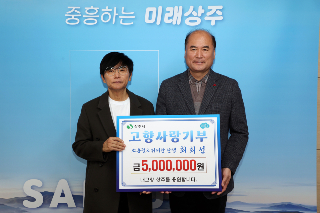 조용필과 위대한탄생의 리더인 최희선이 상주시에 고향사랑기부금 500만원을 전달한 뒤 강영석 상주시장과 기념촬영을 하고 있다. 상주시 제공