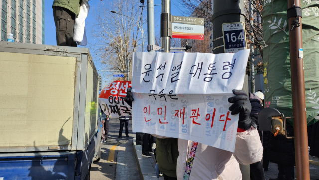 18일 오전 서울서부지방법원 앞에는 윤 대통령 지지자들이 태극기와 성조기 등을 흔들며 