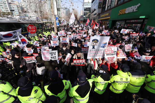 내란 우두머리 혐의로 체포된 윤석열 대통령이 구속 전 피의자심문(영장실질심사)에 전격 출석하기로 한 18일 서울 마포구 서울서부지법 앞에서 윤 대통령 지지자들이 시위하고 있다. 연합뉴스