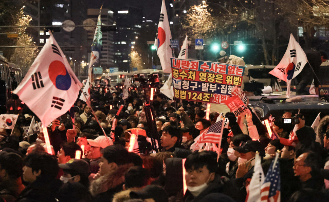 내란 우두머리 혐의로 체포된 윤석열 대통령의 구속 전 피의자심문(영장실질심사)이 종료된 18일 밤 서울 마포구 공덕역 인근에서 윤 대통령 지지자들이 집회를 열고 있다. 연합뉴스