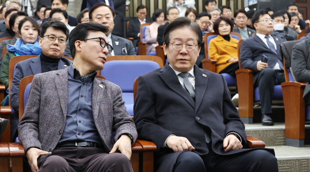 더불어민주당 이재명 대표(오른쪽)가 19일 국회에서 열린 비상의원총회에서 김민석 의원과 대화하고 있다. 연합뉴스