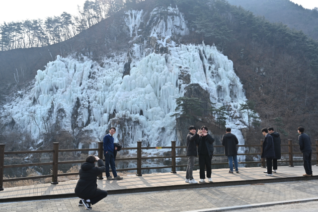 관광객들이 꽁꽁얼어 붙은 영주호 용혈폭포를 배경으로 사진을 촬영하고 있다. 영주시 제공